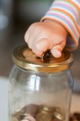 Kinderhand mit Muenze TEaser Gebühren für Kinderbetreuung